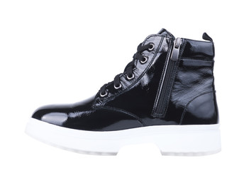 Female boot from black patent leather on a white sole, on a white background.Elegant leather shoes for men and women on a white background.Black shiny patent leather women shoes with white soles.