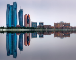 View of Abu Dhabi Skyline on a sunny day with reflection of buildings on water