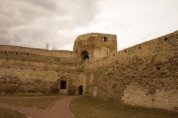 Fototapeta na wymiar The panorama of the medieval fortress was made on a cloudy spring day. Izborsk, Pskov Region, Russia.