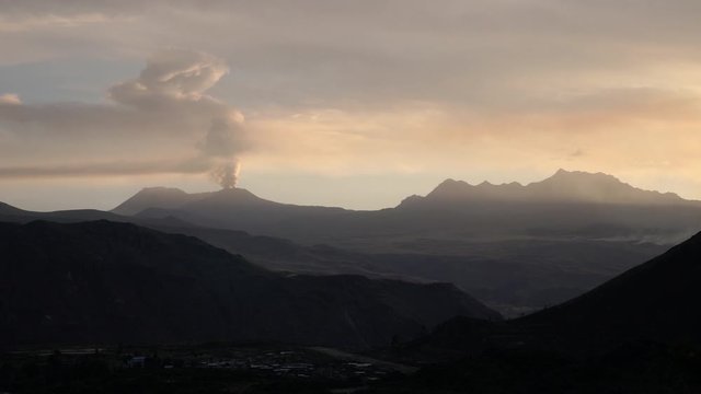Scenic Andes mountain landscape with active volcano and geyser. View from hill close to Chivay in the Colca Canyon near  Arequipa, Peru. Time-lapse of Ampato, Sabancaya and Hualca Hualca during sunset