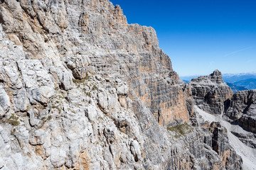Fototapeta na wymiar Fixed-rope Route, climbing a via ferrata route. Italian Alps. Mountain tourism in the Dolomites. Region Brenta, Italy.