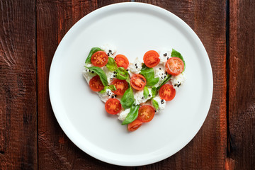Ingredients for Caprese salad in the form of a heart. Symbol of love for Italian food