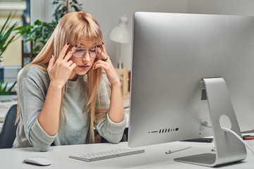 Beautiful blond office worker feels very tired at her new job in the office.