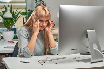 Beautiful blond office worker feels very tired at her new job in the office.