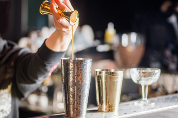 bartender is preparing a cocktail. Bartender pours a cocktail