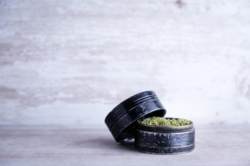 Recreational marijuana and metal grinder on a white stone background after Illinois passes a law to...