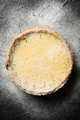 Hygge comfort food. Homemade rustic lemon pie on black background with icing sugar copy space