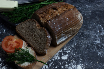 Bread on a dark background on a wooden board