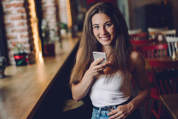 Woman using phone  in a cafe.