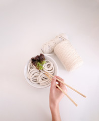 woman's hands with some sticks and cloth noodle
