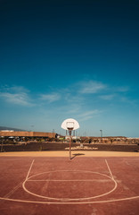red basketball court and a big blue sky