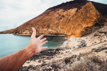 hand indicating a heavenly beach