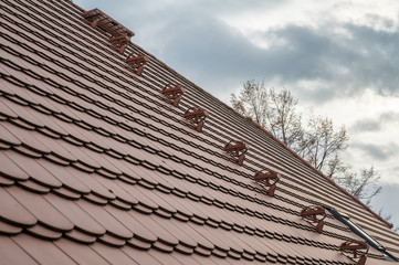 Bieberschwanzplatten und Dachtritt auf einem Hausdach im Detail