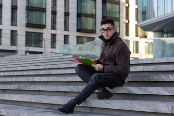 Obraz premium young male Asian student sitting on steps of University read books and thought