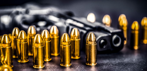Bullets and handcuffs. Close-up of 9mm pistol. Gun and weapon with bullets amunition on black...