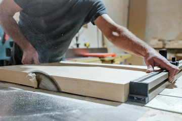 Caucasian man carpenter cutting wood with circular saw creating new furniture