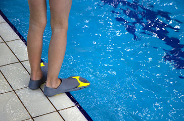 close up human legs swimmer fins near pool
