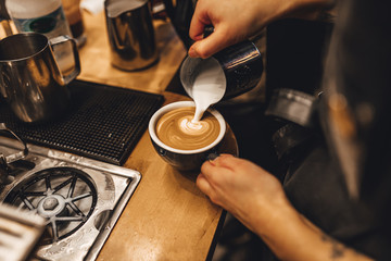 Fototapeta na wymiar Barista making cappuccion coffee in coffee shop