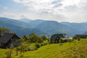 View of the Carpathian Mountains and the village Kvasy among the mountains and hills, beautiful scenery on a sunny clear day Ukraine, Europe, Carpathian Mountains