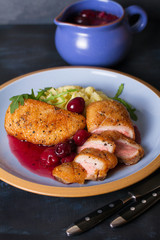 Duck breast fillet with cherry wine sauce and mashed potato on blue plate, dark background. Vertical image