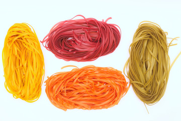 Isolated colored spaghetti nests on a white background. Top view
