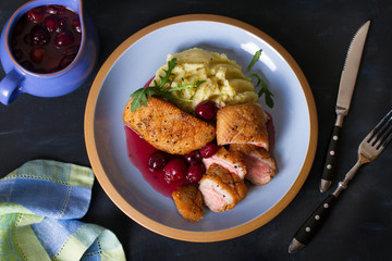 Duck breast fillet with cherry wine sauce and mashed potato on blue plate, dark background. Overhead horizontal image