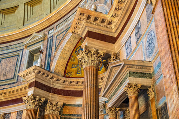 Fototapeta na wymiar Rome, Italy - Interior of Roman Pantheon ancient temple, presently catholic Basilica, with its reach decorations, arches and colonnades covered with golden and colorful paintings