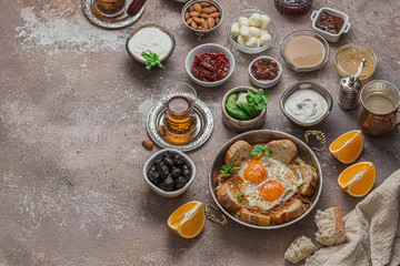 Traditional turkish breakfast with fried eggs, tea, vegetables, chees and olives, copy space