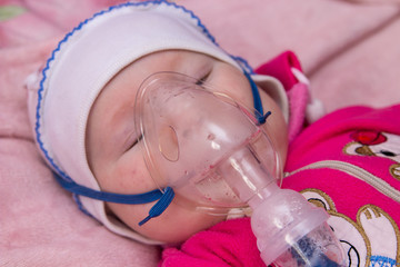 treatment of infant from Nebulizer virus,the baby lies and breathes through the mask of an inhaler,...