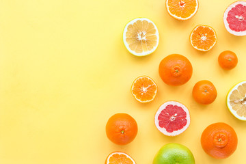 Fresh citrus fruit on yelllow background, flat lay, top view