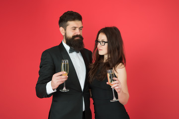 Cheers to Valentines Day. Couple in love red background. Sexy woman and bearded man hold champagne glasses. Valentines day celebration. Having party for Valentines. Happy Valentines Day