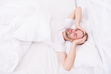 Sleep problems can lead to headaches in morning. Handsome man relaxing in bed. Snoring can increase risk headaches. Common symptom of sleep apnea. Causes of early morning headache. Migraine headaches