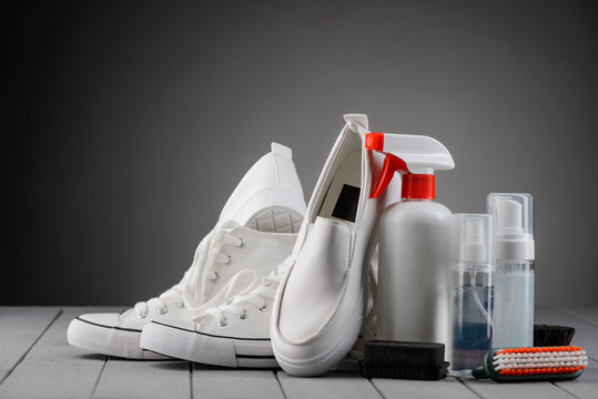 White shoes and cleaning kit on gray background
