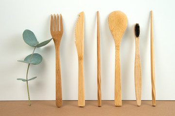 Eco friendly bamboo cutlery set and eucalyptus leaves on a white background. Zero waste concept.