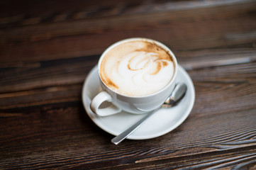 Cup of coffee latte on old wooden background