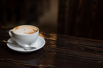 Cup of coffee latte on old wooden background