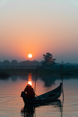 Asian fishermen are  their boats on the lake at sunrise