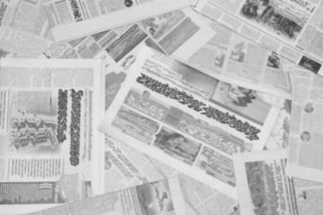 Lots of old newspapers on horizontal surface. Background texture, top view, blurred 