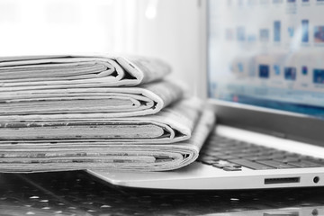 Newspapers and Laptop. Different Concepts for News -  Network or Traditional Tabloid Journals. Data...