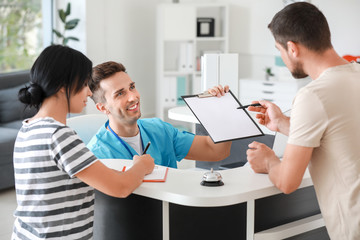 Male receptionist working with patients in clinic