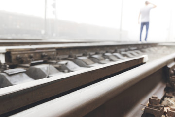 Stressed man standing railway track. Concept of choice