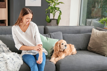 Scratching young woman with pet allergy at home