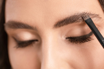 Naklejka premium Makeup artist working with beautiful young woman, closeup