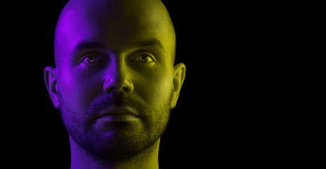 Portrait of a young man. Two-tone lighting. Place for text.