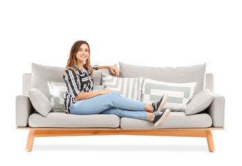 Obraz premium Young woman relaxing on sofa against white background