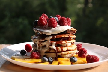 Wieża pancake z owocami i bitą śmietaną