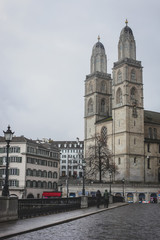 Fototapeta na wymiar Vertical photo of Grossmunster church and a part of Zurich old town in a cold, cloudy winter like environment.