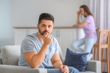 Upset young couple after quarrel at home