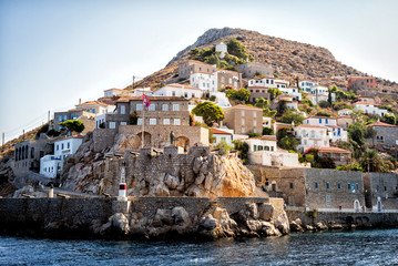 Historic shoreline with ramparts and canons and statue in Hydra, Greece