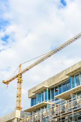 High-rise building under construction. The site with cranes against blue sky